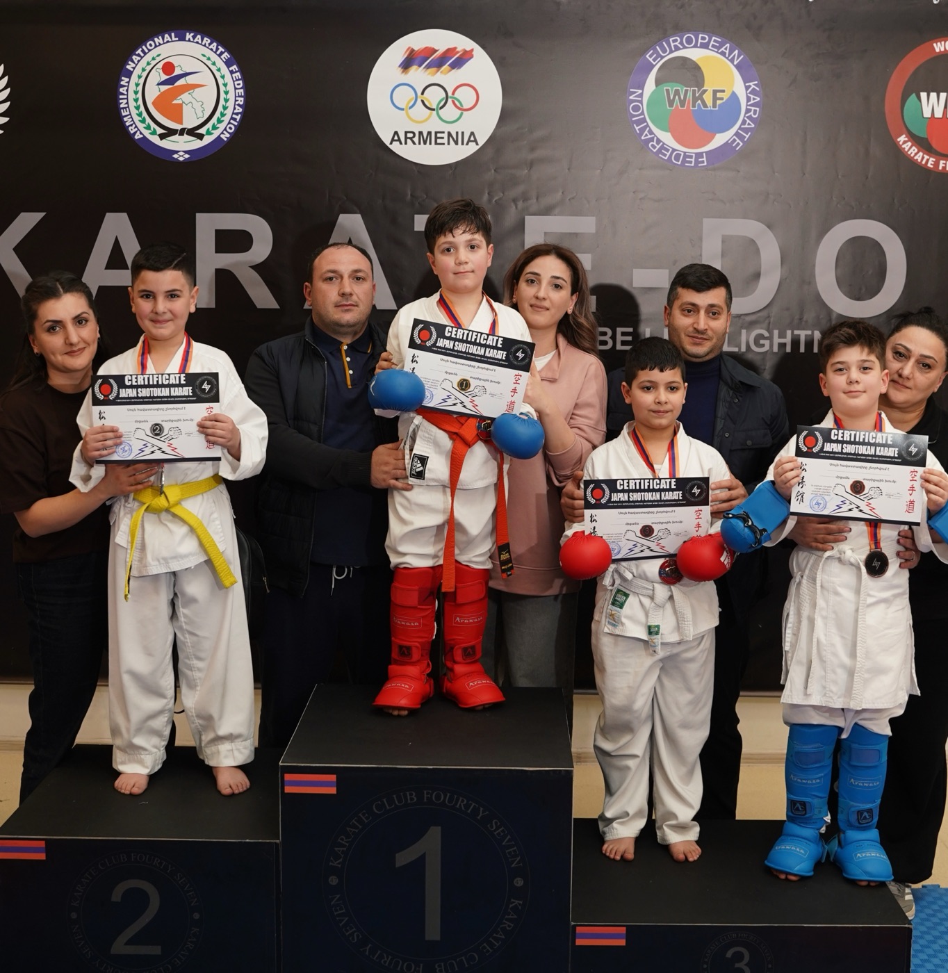 Medal-winning students with parents and coach