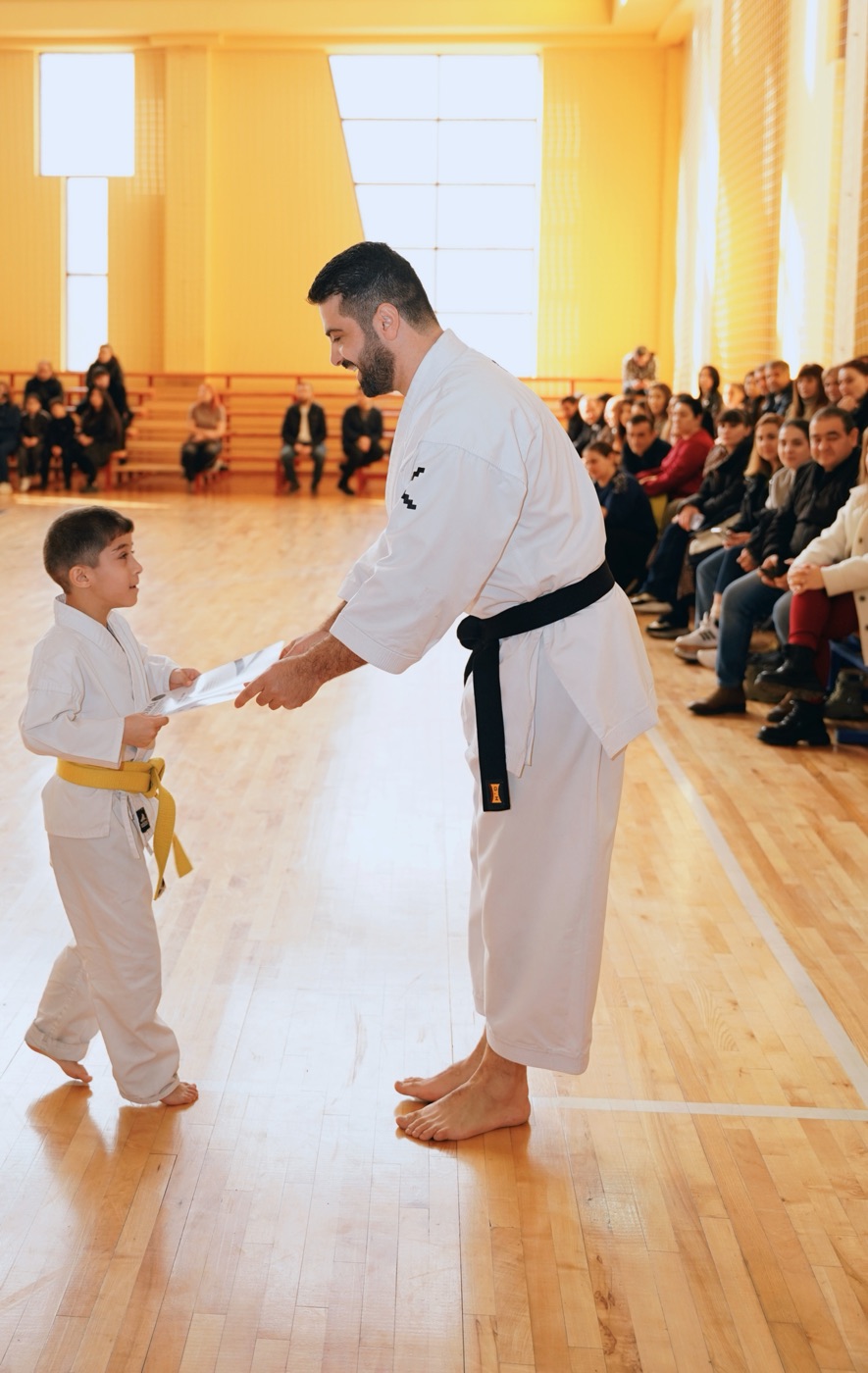 Coach awarding a belt to a student